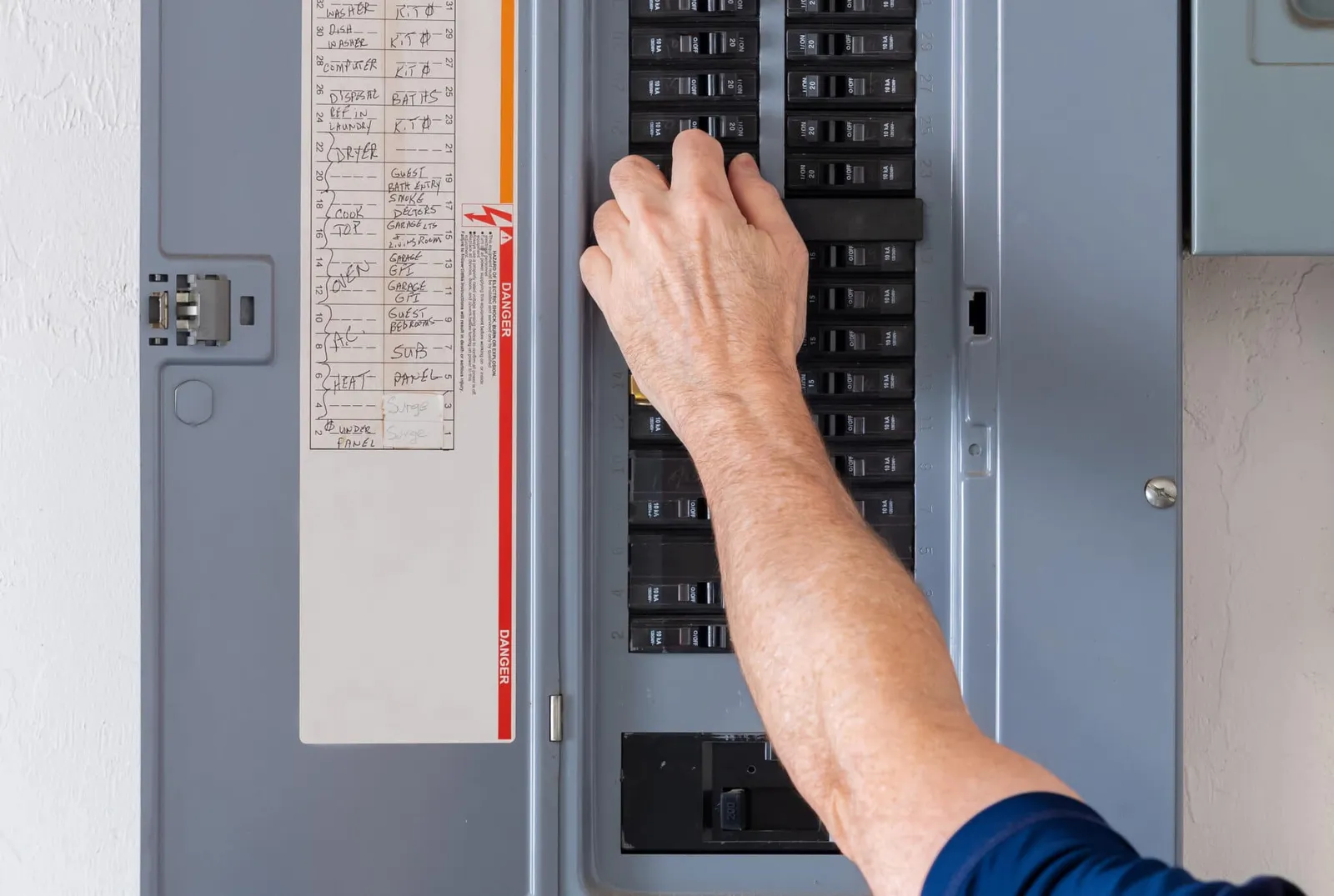 Electrician working in a breaker panel during a replacement
