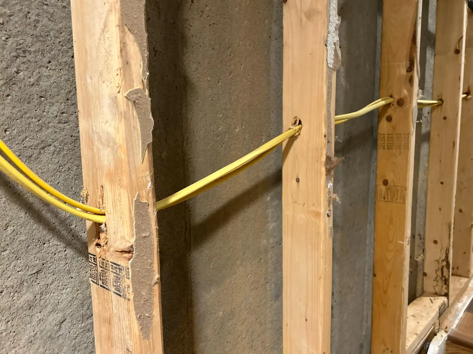 New electrical cable run through drilled wall studs during a house rewiring