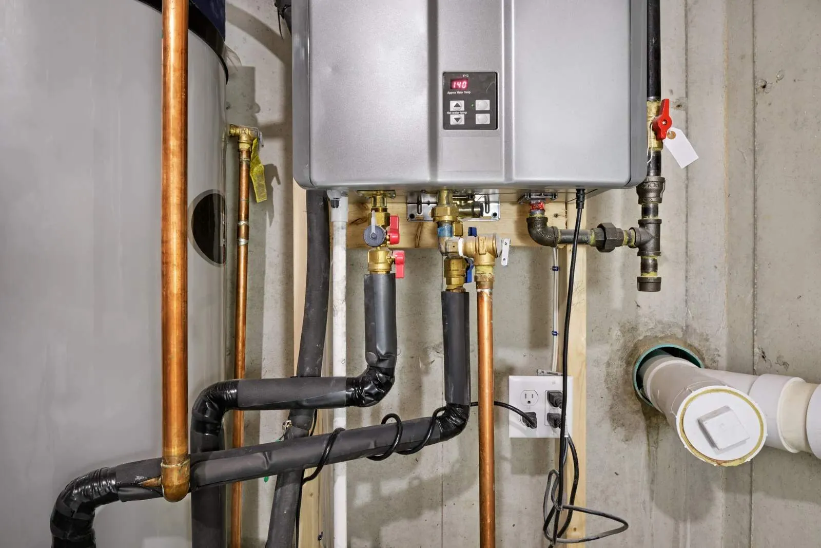 Service valves, copper water lines and the gas connection under a newly installed tankless water heater