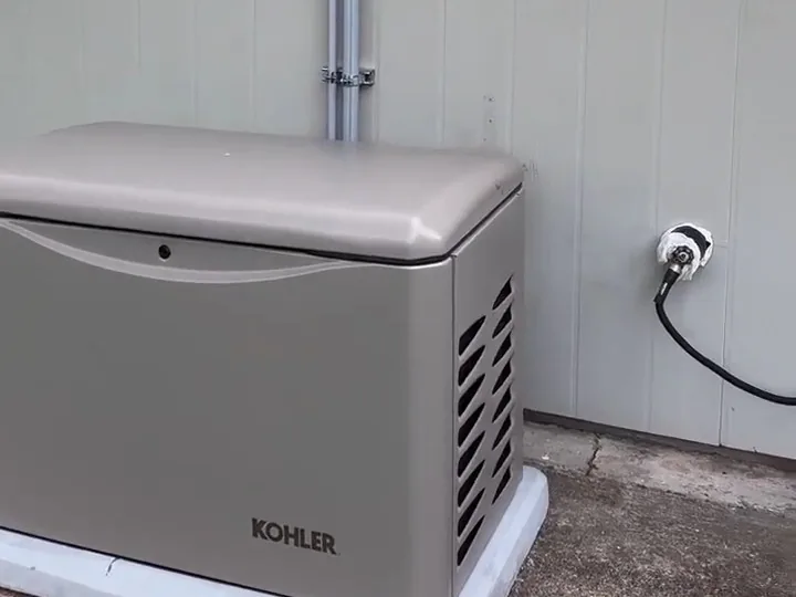 Whole-house standby generator on a pad beside a Houston home, with conduit running up the wall